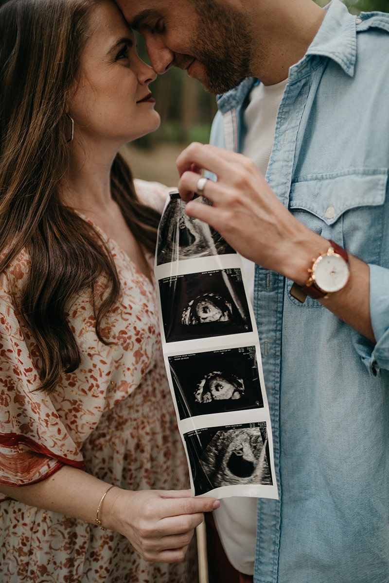Close up of Couple holding sonogram photos announcing their pregnancy
